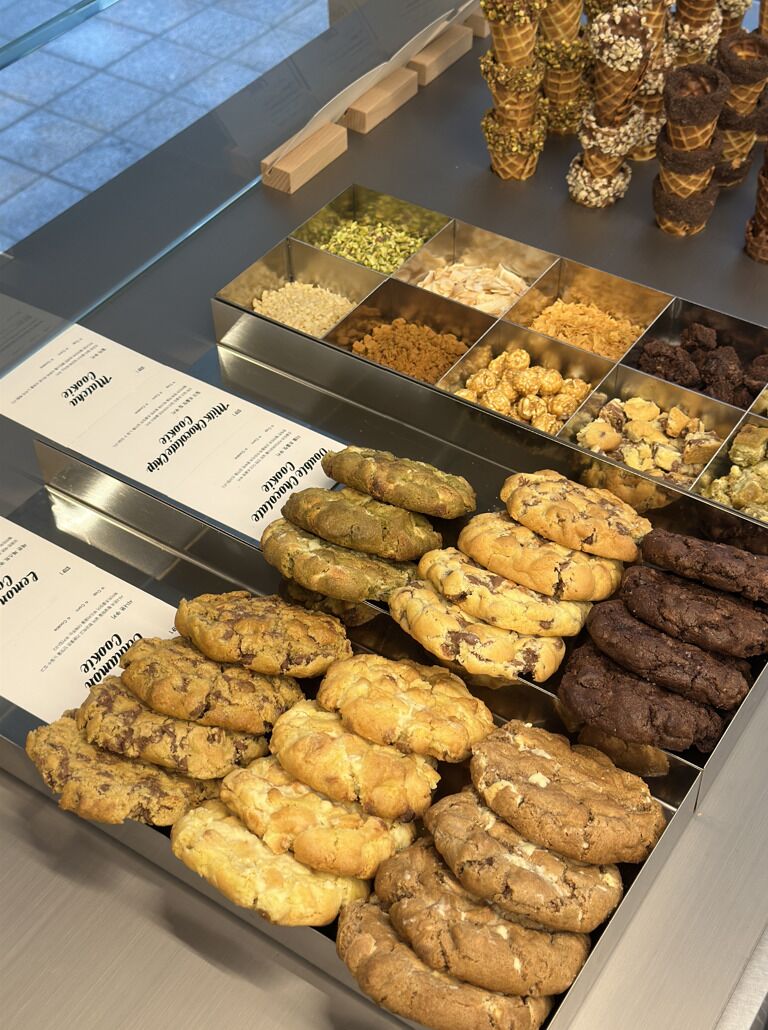 A display of assorted cookies and chocolates in a bakery setting.
