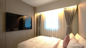 A hotel room with a bed, a flat-screen TV mounted on the wall, and curtains on the windows. - Hotel Tradiup by the Designers (Seoul)