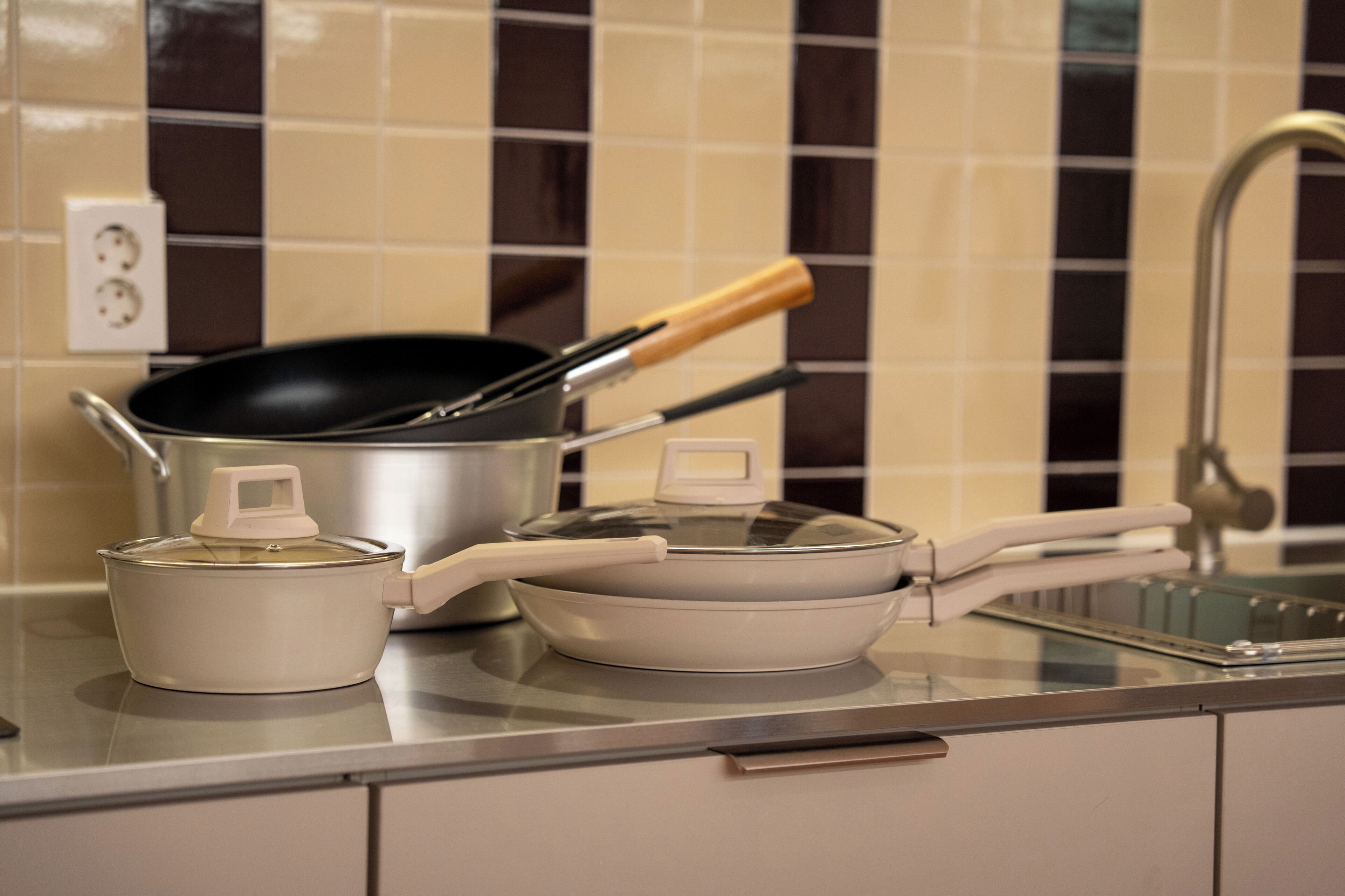 A kitchen counter with a pot, a pan, and a stove.