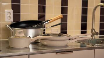 A kitchen counter with a pot, a pan, and a stove.