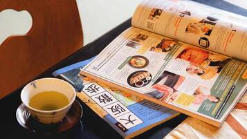 A magazine on a tray with a cup of tea.