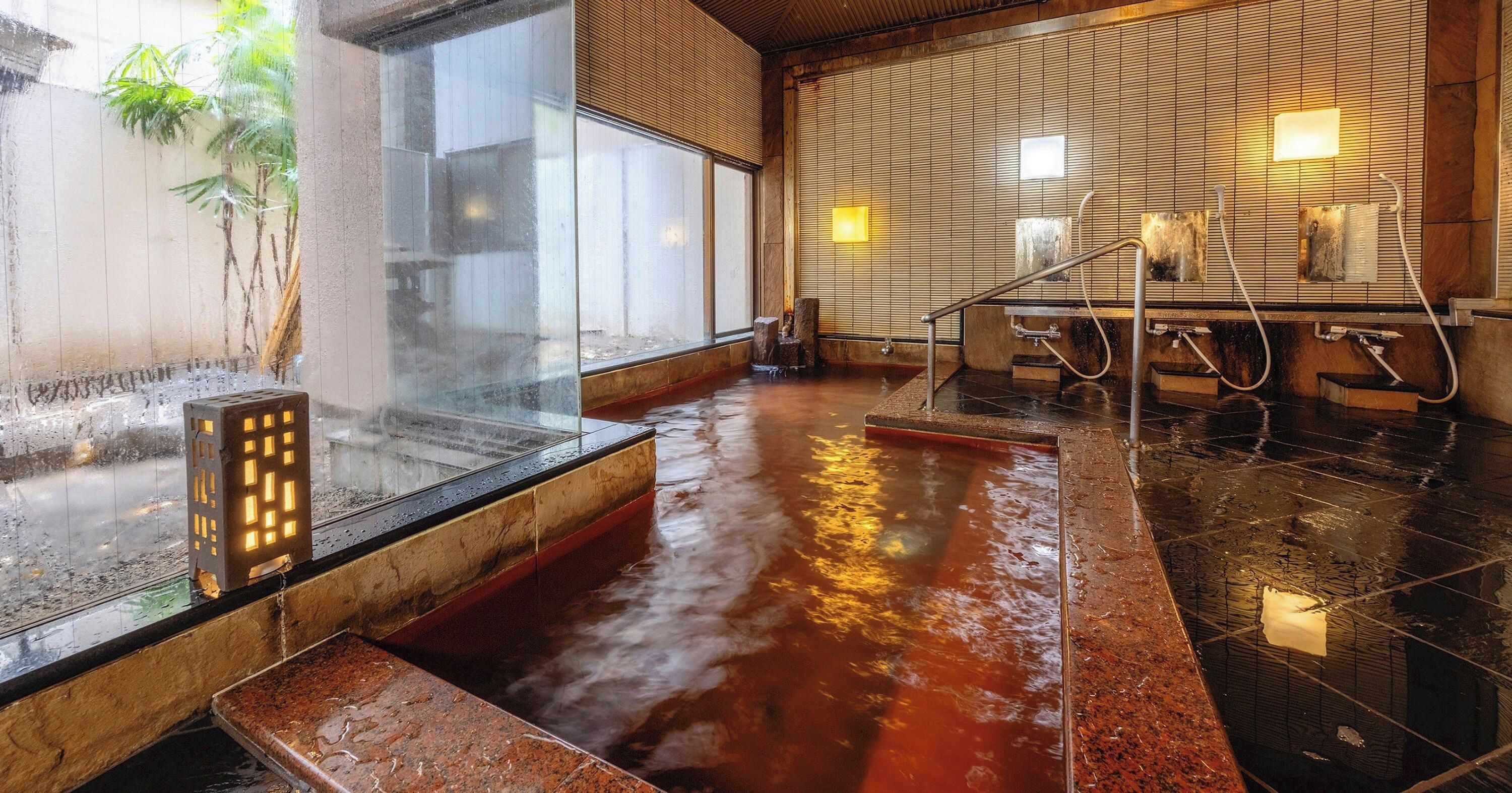 A wet floor with a hot spring area, wooden walls, and a glass partition.