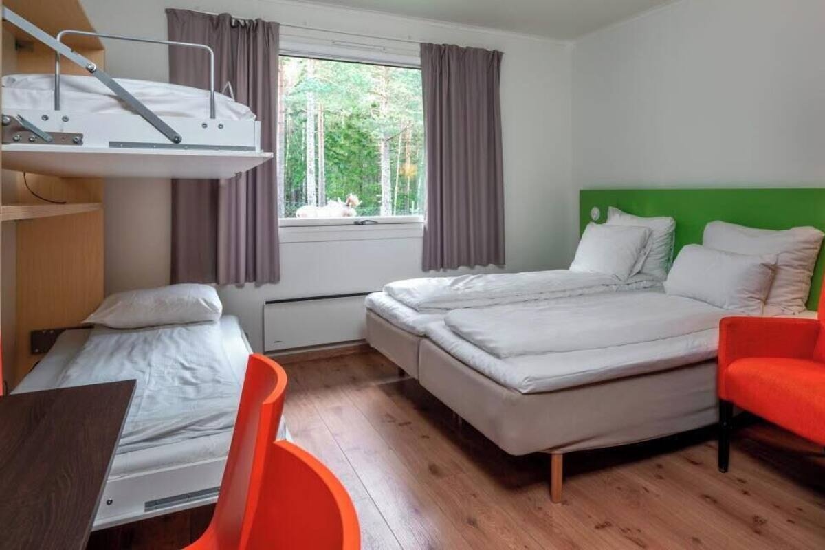 Um quarto com uma cama de solteiro, uma cama individual, uma escrivaninha e uma cadeira.