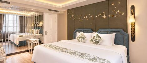 A hotel room with a large bed, a mirror, a bedside table, and a wall with butterfly decorations.