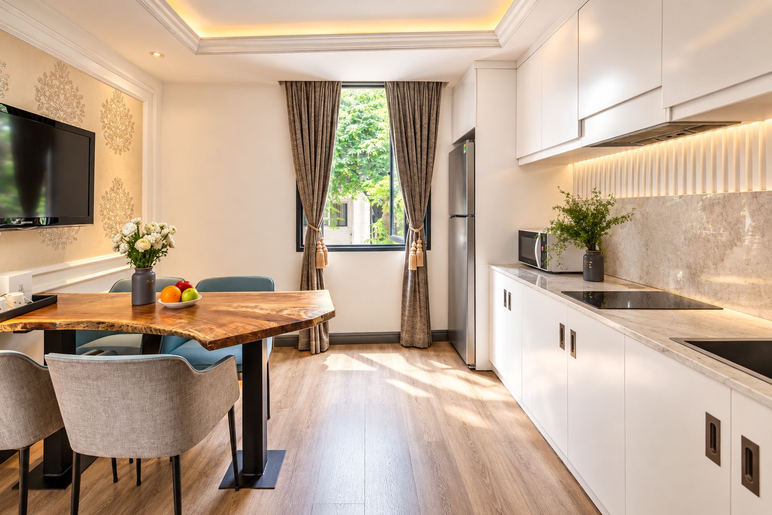 Una cocina moderna con comedor, televisor de pantalla plana y vistas a zonas verdes.
