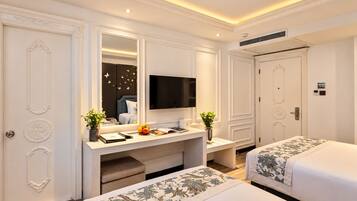 Habitación de hotel con una cama grande, un escritorio con televisor de pantalla plana, cómoda y espejo.
