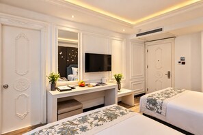 A hotel room with a large bed, a desk with a flat-screen TV, a dresser, and a mirror. - A&EM Saigon Hotel (Ho Chi Minh City)