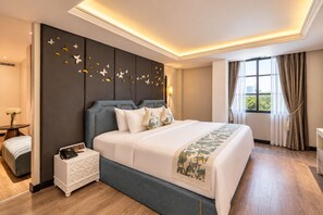 Ein Hotelzimmer mit einem großen Bett, einem Nachttisch mit Telefon, einem Fenster mit Vorhängen und einer Wand mit Schmetterlingsdekorationen.