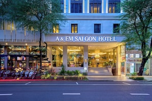 A & EM SAIGON HOTEL met een moderne gevel, grote glasramen en een goed verlichte entree.