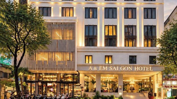 Een hotel met meerdere verdiepingen, een moderne gevel, een duidelijk zichtbare ingang en een bord met de tekst 'A & EM SAI GON HOTEL'.