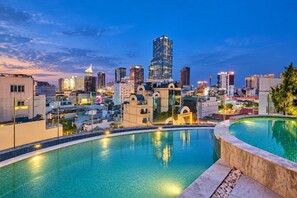 Stadtansicht mit Poolbereich, der eine geschwungene Kante und klaren Blick auf den Horizont bietet.