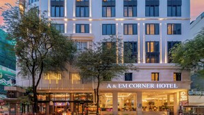 Ein modernes Hotel mit geschwungener Fassade, großen Fenstern und einem gut beleuchteten Eingang.