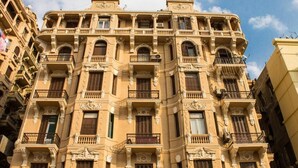 Un immeuble à plusieurs étages, doté d’éléments architecturaux raffinés, notamment des balcons et des moulures décoratives.