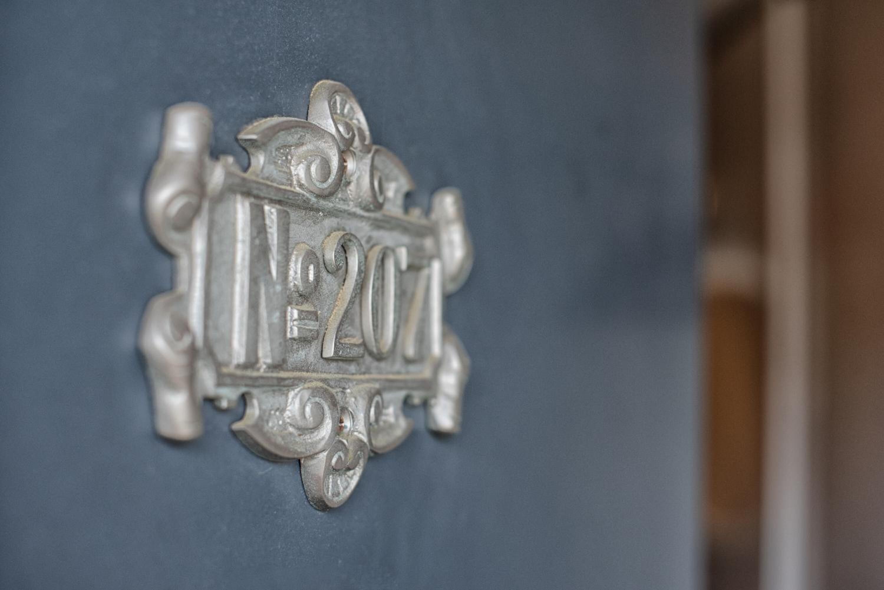 A close-up of a metallic plaque with the inscription "No. 207".