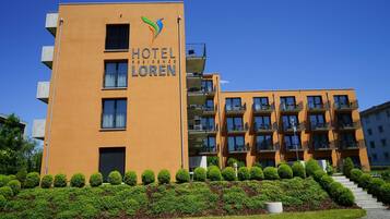 A modern hotel building with a prominent sign reading "HOTEL RESIDENCE LOREN".