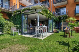 Un patio al aire libre con cerramiento de vidrio, una zona de bar y un conjunto de asientos.