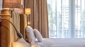 Una habitación de hotel con cama, lámpara y cortinas.