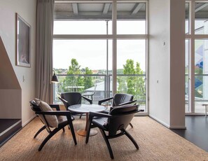 A modern room with a large window, a round table, and four chairs.