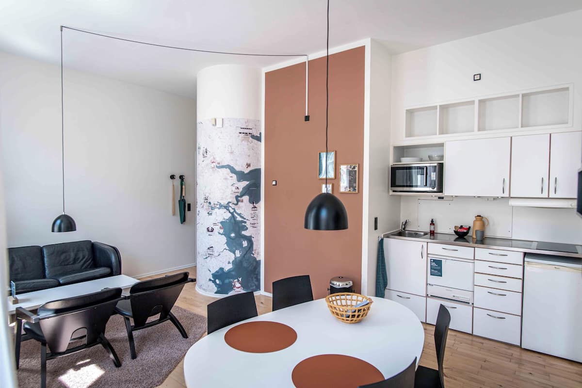 A modern kitchen with white cabinets, a microwave, and a sink.
