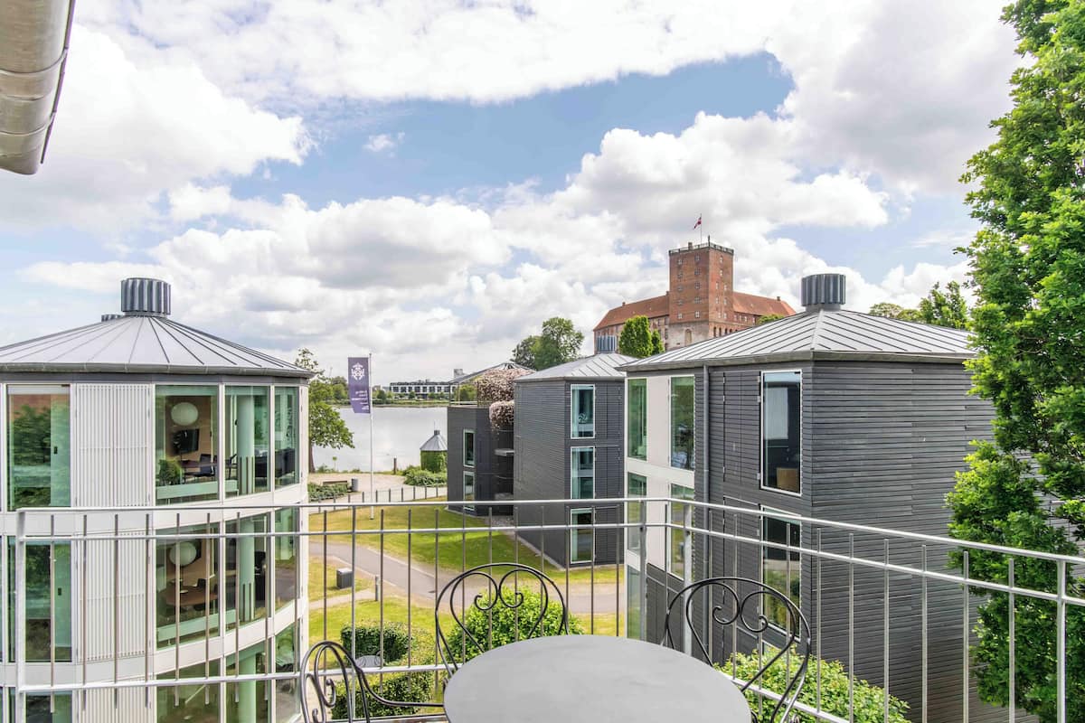 A modern building with a balcony, a table, and chairs.