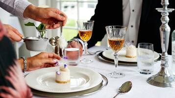 A formal dining setting with white plates, clear glasses, and silverware.