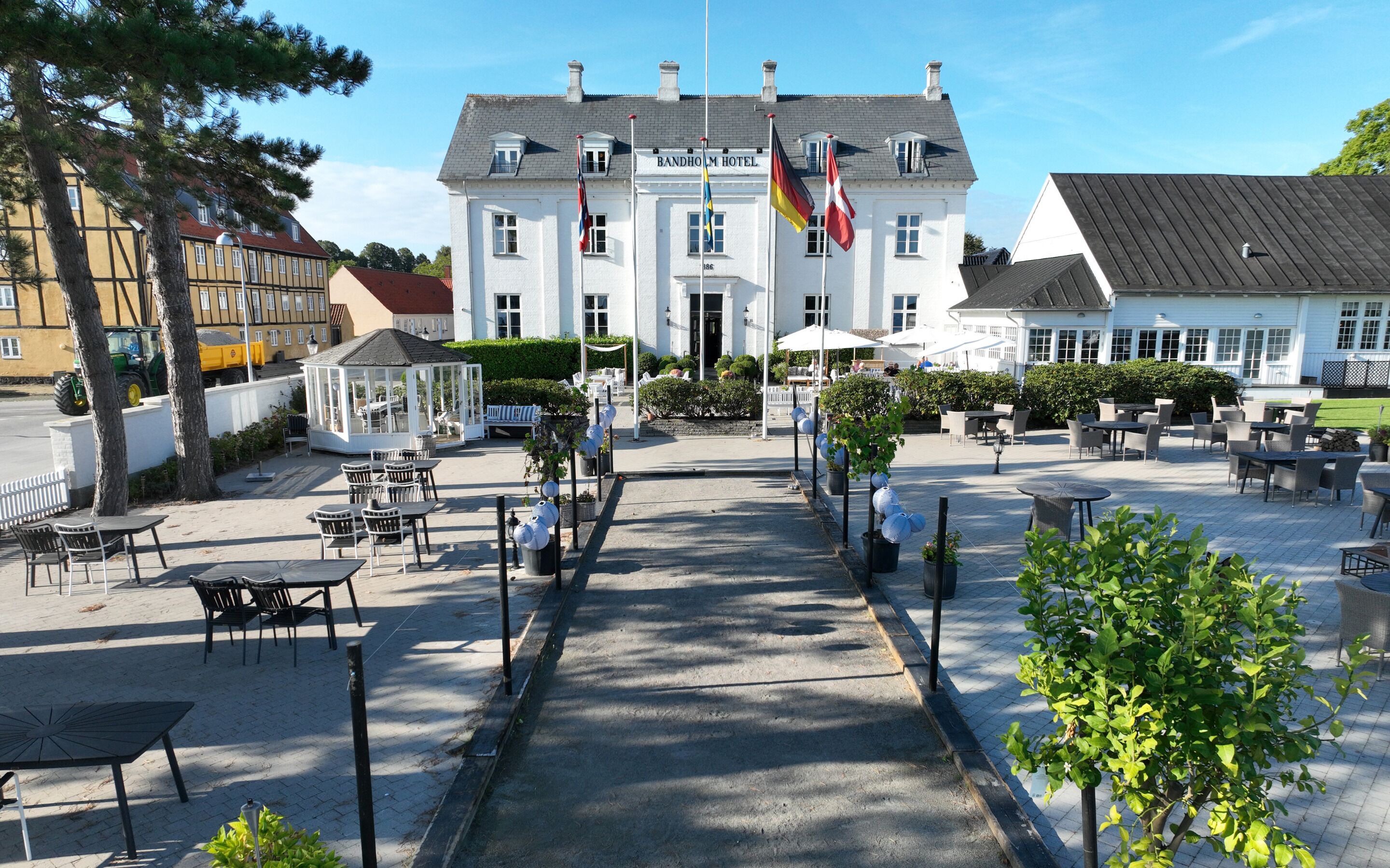 A hotel with a central courtyard, outdoor seating, and a flag display.