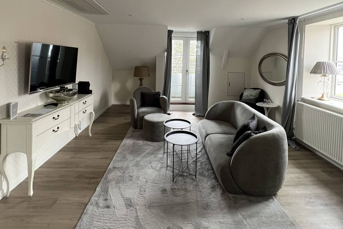 Un salon moderne avec un téléviseur à écran plat, un canapé, une table basse et une table à manger.
