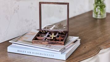 A wooden jewelry box with a mirror on top, placed on a stack of books.