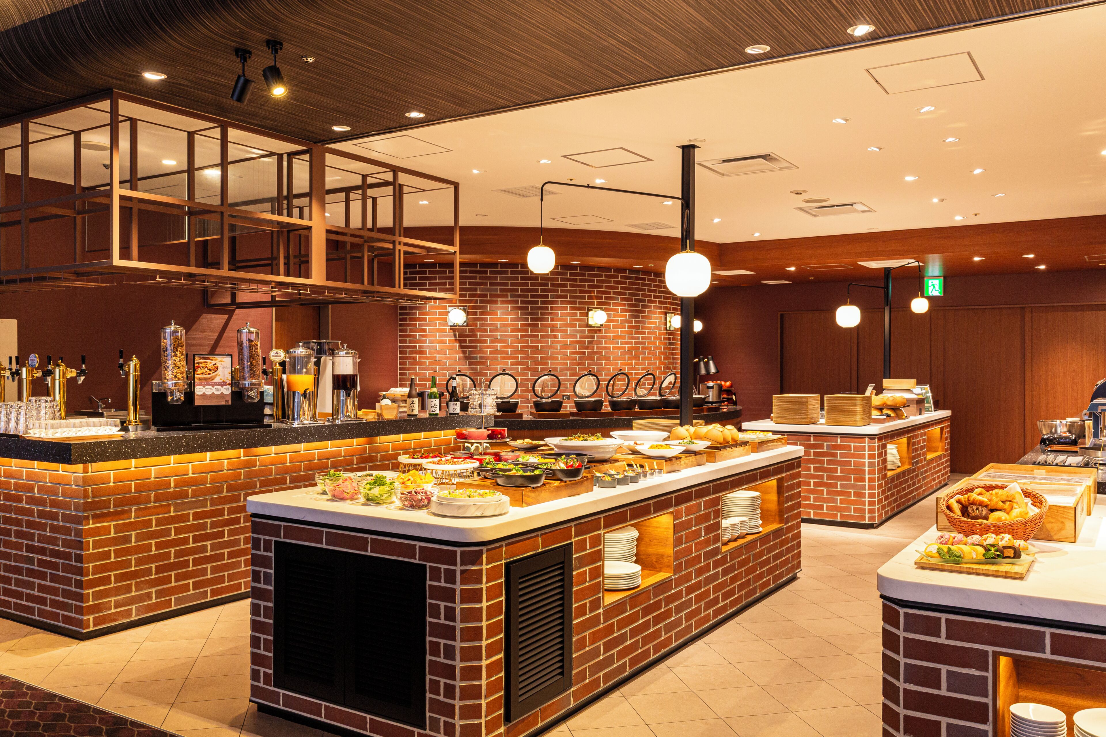 A buffet area with multiple food stations, a coffee bar, and a seating area with a high ceiling and wooden accents.
