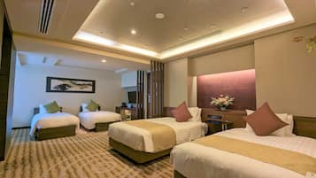 A hotel room with two beds, a TV, a desk, and a bathroom.