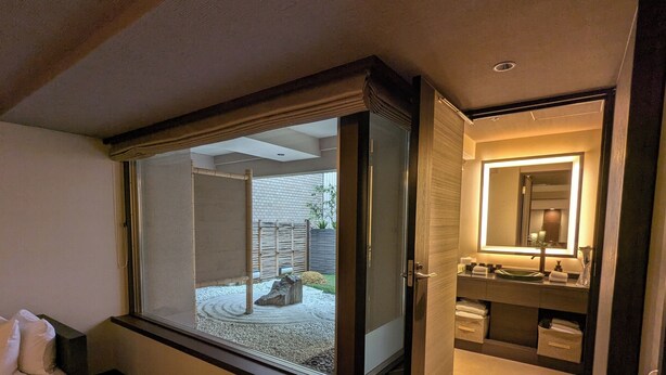 Un baño moderno con un ventanal grande, un lavamanos empotrado y un espejo.