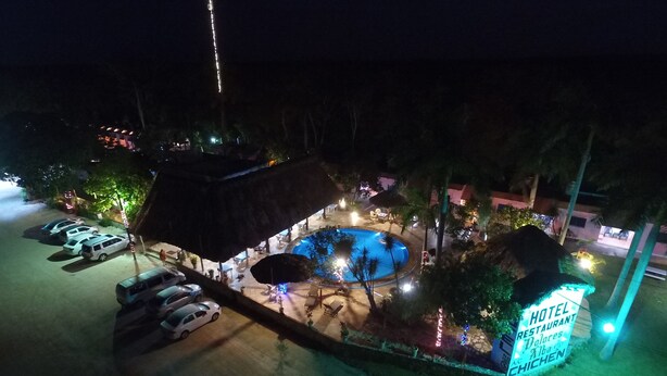 Un hotel con piscina, mobiliario exterior y un letrero que indica un restaurante.