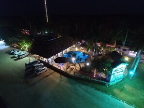 A hotel with a swimming pool, outdoor seating, and a sign indicating a restaurant. - Hotel DORALBA INN Chichén (Chichen Itza)