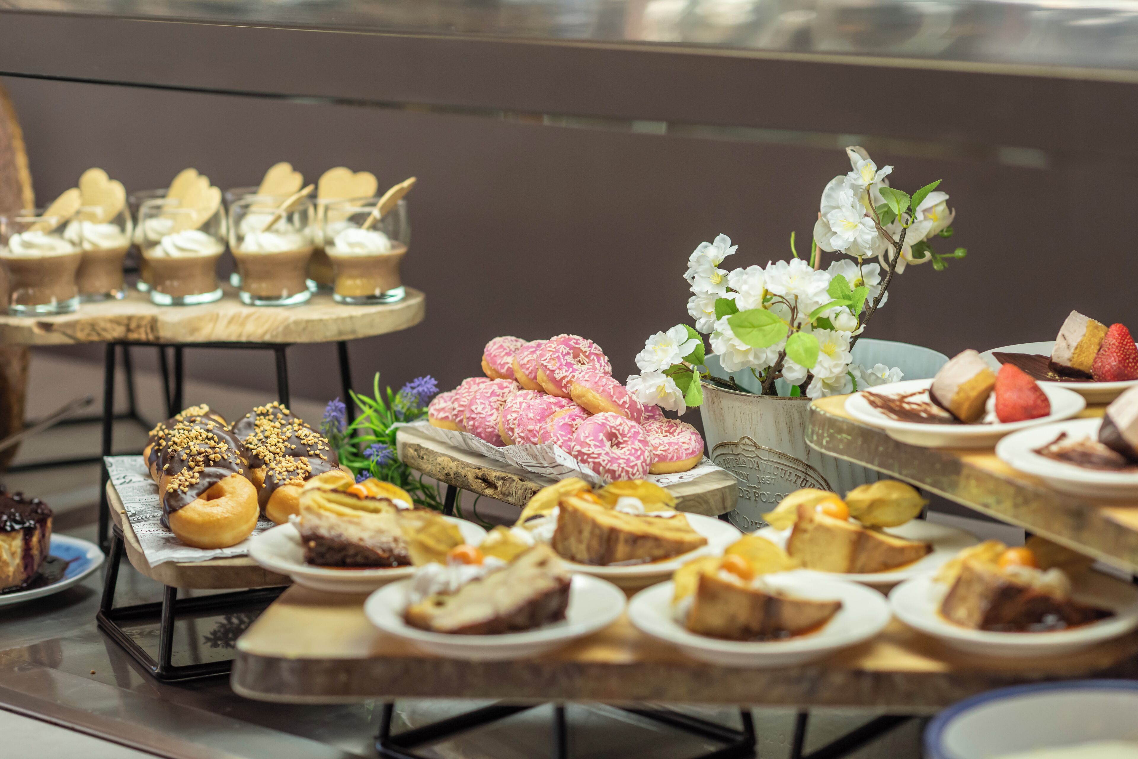 A variety of desserts displayed on tables in a dining area.