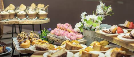A variety of desserts displayed on tables in a dining area.