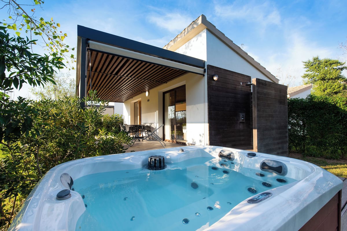 A modern house with a hot tub in the garden.