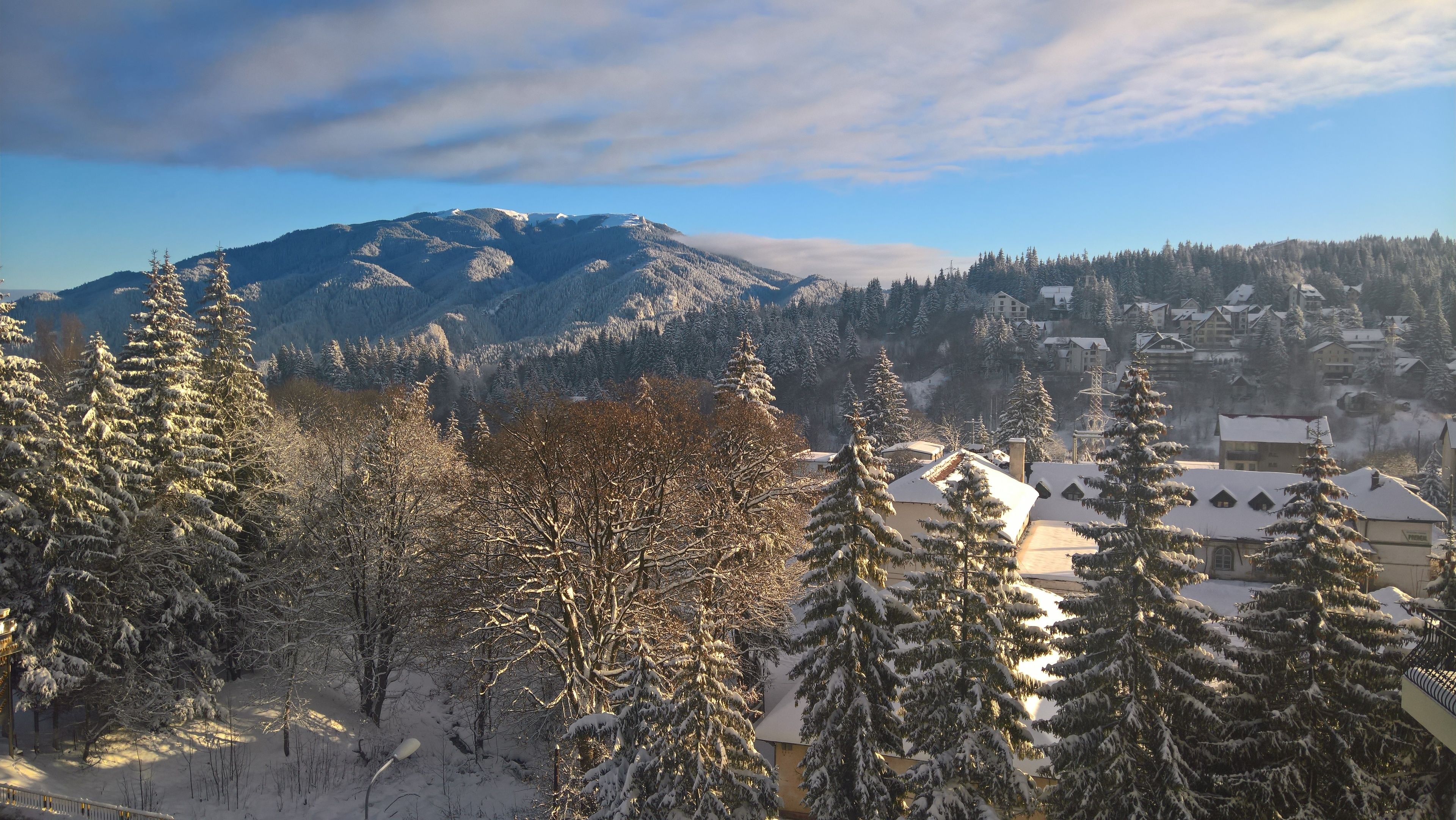 A snow-covered mountain landscape with a town in the foreground.