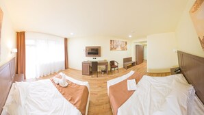 A hotel room with two beds, a desk, a chair, a television, and a wardrobe. - Hotel Piemonte (Predeal)
