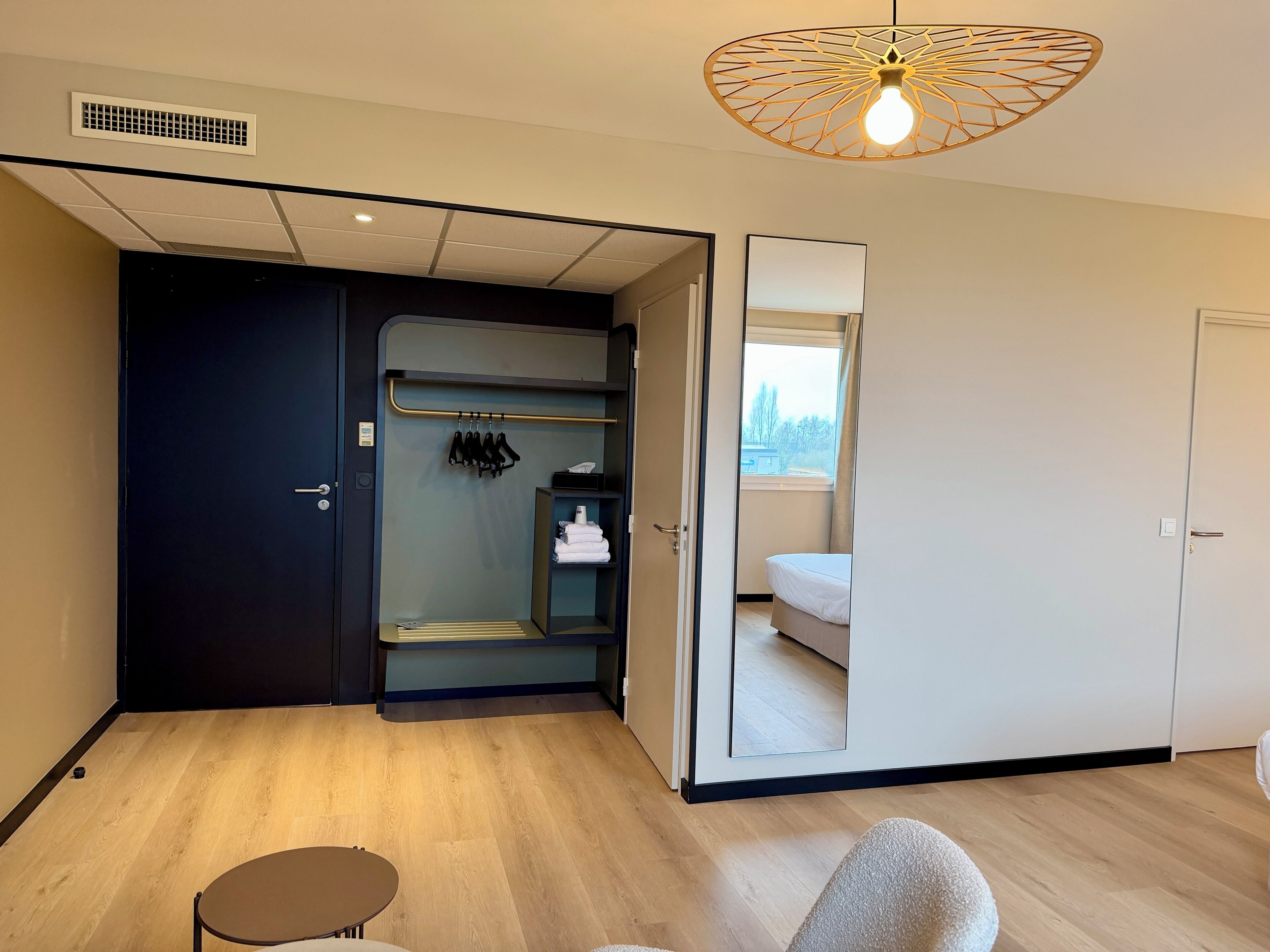 Une pièce compacte dotée d’un placard intégré, d’un petit coin salon et donnant sur l’extérieur par une porte.