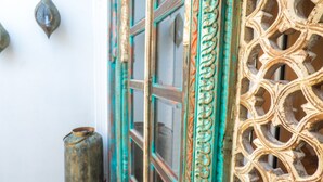 A room with a large window, a decorative metal gate, and a small metal container. - Antonio S House (Sitges)