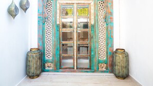 A traditional door with intricate carvings and a decorative archway, flanked by two ornate vases. - Antonio S House (Sitges)