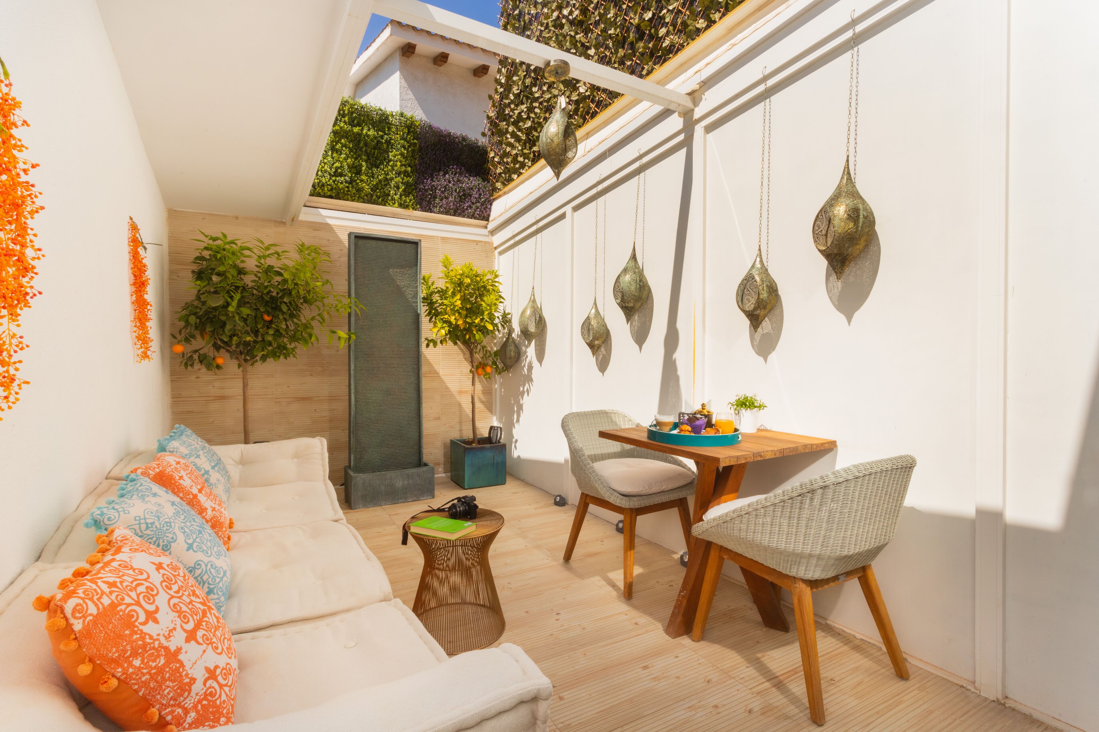 A cozy indoor space with a sofa, chairs, a small table, and hanging decorative items.