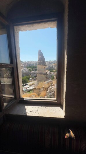 Una habitación con ventana que da a un paisaje rocoso.