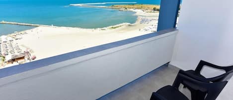 A balcony with a view of a beach and ocean.