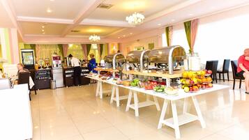 A buffet setup with various food items and a beverage station.