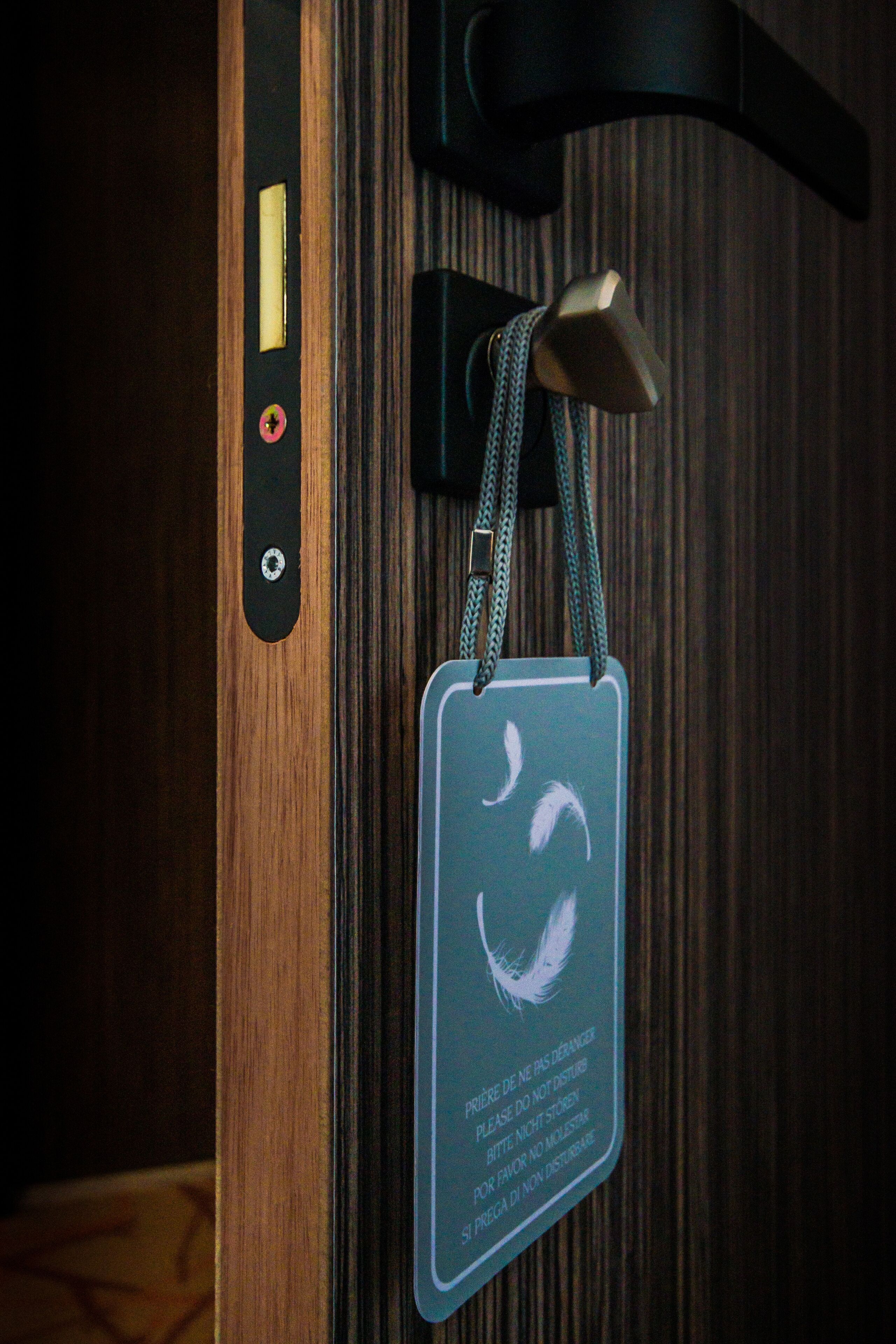 Une porte dotée d’une serrure numérique et d’un trou de serrure, une petite pancarte ornée du symbole du recyclage et une chaîne suspendue au trou de serrure.