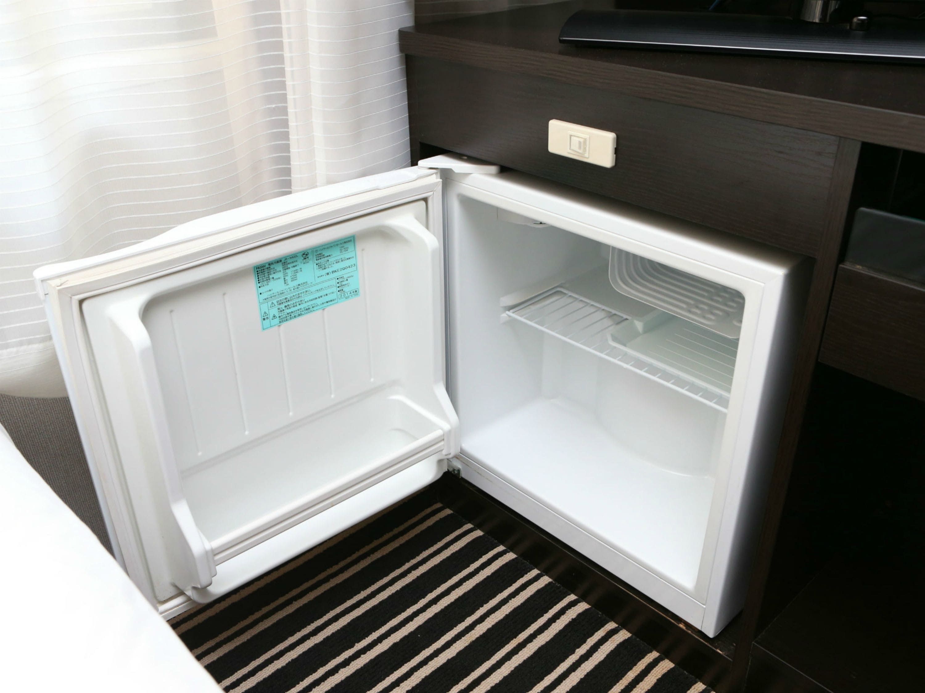 Un refrigerador abierto con un panel de control y una nota en la puerta.