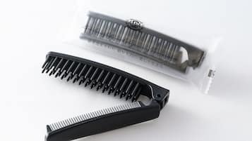A black comb and a comb case with Japanese text.