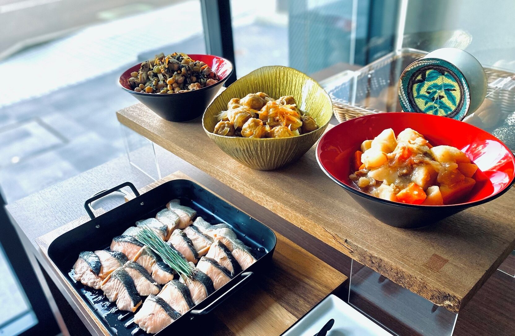 Uma bancada de cozinha com diversos pratos, incluindo peixe e legumes.