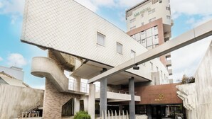Un edificio moderno con un diseño angular distintivo, que presenta un alero pronunciado y una estructura de columna central.